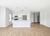 Thumbnail 71 of 87 - A kitchen with a white counter and wooden floors.