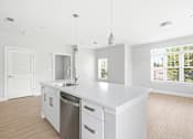 Thumbnail 85 of 87 - A white kitchen with a sink and a window.