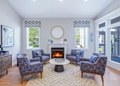 Thumbnail 36 of 52 - A living room with a fireplace and grey chairs.