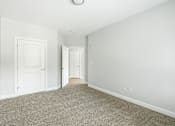 Thumbnail 67 of 87 - A room with a carpeted floor and two white doors.