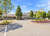 Thumbnail 84 of 87 - A large building with a parking lot in front of it.