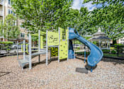 Thumbnail 18 of 40 - A playground with a blue slide and a yellow climbing frame.