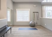 Thumbnail 12 of 40 - A room with a large exercise ball and a bench.