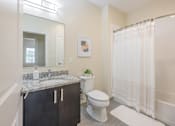 Thumbnail 27 of 40 - A bathroom with a toilet, sink, and shower.