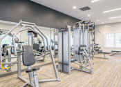 Thumbnail 11 of 40 - A gym with a variety of equipment including a leg press machine.