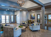 Thumbnail 22 of 35 - A modern living room with grey couches and a wooden floor at Axis at Lakeshore Apartments, Bridgewater, MA 02324