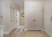 Thumbnail 17 of 35 - A hallway with white doors and a patterned rug on the floor at Axis at Lakeshore Apartments, MA,02324