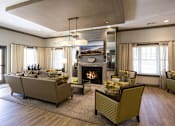 Thumbnail 23 of 35 - A living room with a fireplace and a couch at Axis at Lakeshore Apartments, Bridgewater, MA 02324