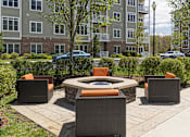 Thumbnail 34 of 35 - A patio with a fire pit and chairs at Axis at Lakeshore Apartments, Bridgewater