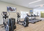 Thumbnail 26 of 35 - A gym with treadmills and elliptical machines at Axis at Lakeshore Apartments, Bridgewater, Massachusetts