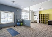 Thumbnail 27 of 35 - A room with a blue mat on the floor and exercise equipment at Axis at Lakeshore Apartments, Bridgewater