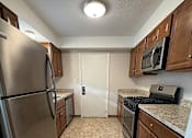 Thumbnail 11 of 18 - a kitchen with stainless steel appliances and wooden cabinets at Hidden Brook Apartment Homes Apartments, Massachusetts