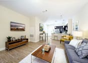 Thumbnail 3 of 35 - A living room with a grey couch and a wooden coffee table at Axis at Lakeshore Apartments, MA,02324