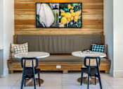 Thumbnail 9 of 28 - A wooden bench with a grey cushion and a painting of flowers above it.