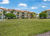Thumbnail 25 of 28 - A grassy area in front of a row of apartment buildings.