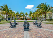 Thumbnail 27 of 28 - A set of four chairs and a table are arranged in a circle on a brick patio.