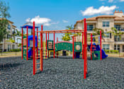 Thumbnail 24 of 28 - A playground with a red swing set and a blue slide.