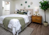 Thumbnail 73 of 85 - A bedroom with a bed, nightstand, and a plant.