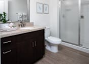 Thumbnail 76 of 85 - A bathroom with a white toilet and a walk-in shower.