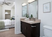 Thumbnail 77 of 85 - A bathroom with a white tub, a sink, a mirror, and a bedroom with a bed and a window.