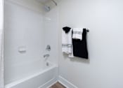 Thumbnail 79 of 85 - A white bathroom with a white tub and a white shower curtain.