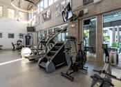 Thumbnail 22 of 85 - A gym with a variety of exercise equipment including treadmills, stationary bikes, and weight machines.
