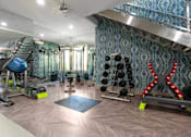Thumbnail 28 of 85 - A gym with a variety of equipment including a bench, weights, and a mirror.