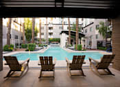 Thumbnail 30 of 85 - Three lounge chairs are positioned in front of a pool.