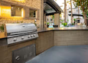 Thumbnail 55 of 85 - A modern outdoor kitchen with a built-in grill and seating area.