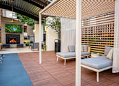 Thumbnail 51 of 85 - A patio with a fireplace and a sofa.