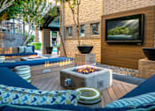 Thumbnail 42 of 85 - A modern outdoor living space with a fire pit and seating area.