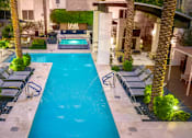 Thumbnail 32 of 85 - A swimming pool surrounded by palm trees and lounge chairs.