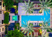 Thumbnail 31 of 85 - A pool surrounded by palm trees at night.