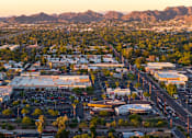 Thumbnail 4 of 85 - A cityscape with a large parking lot in the foreground and mountains in the background.