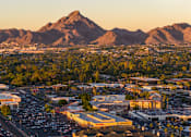 Thumbnail 5 of 85 - A cityscape with a mountain in the background during sunset.