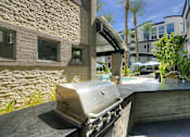Thumbnail 47 of 72 - A BBQ grill is in the foreground of a patio area.