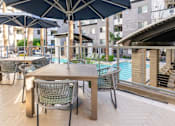Thumbnail 35 of 72 - A table with chairs and umbrellas is set up on a patio.