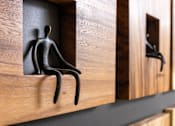 Thumbnail 20 of 72 - A black sculpture of a person is sitting in a wooden compartment.