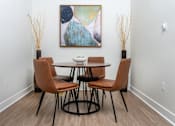 Thumbnail 49 of 72 - A dining table with four chairs and a painting on the wall.