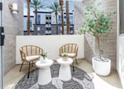 Thumbnail 51 of 72 - A patio with two chairs and two tables.