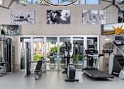 Thumbnail 16 of 72 - A gym with treadmills, exercise bikes, and other equipment.