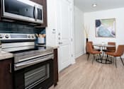 Thumbnail 54 of 72 - A modern kitchen with a dining table and chairs.