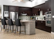 Thumbnail 13 of 72 - A modern kitchen with dark wood cabinets and a central island.