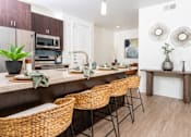 Thumbnail 58 of 72 - A kitchen with brown wicker chairs and a white counter.