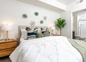 Thumbnail 62 of 72 - A bedroom with a large bed and a green plant.