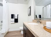 Thumbnail 68 of 72 - A bathroom with a white toilet, a sink, and a mirror.
