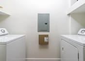 Thumbnail 69 of 72 - A laundry room with a washer and dryer on each side and a cabinet in the middle.