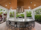 Thumbnail 38 of 38 - A modern outdoor dining area with a glass table surrounded by chairs.