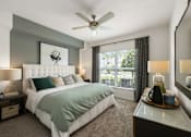 Thumbnail 34 of 38 - A bedroom with a large bed and a ceiling fan.