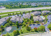 Thumbnail 45 of 49 - an aerial view of a large community with a lake and highway in the background